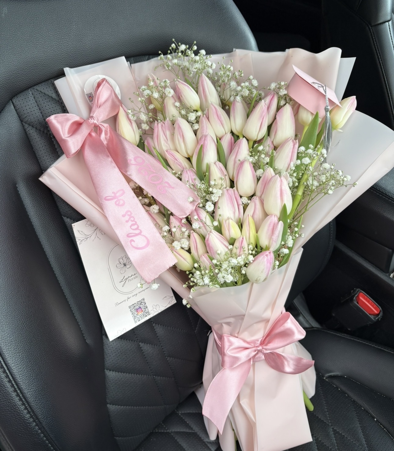 Pink tulip bouquet with satin bows and graduation cap